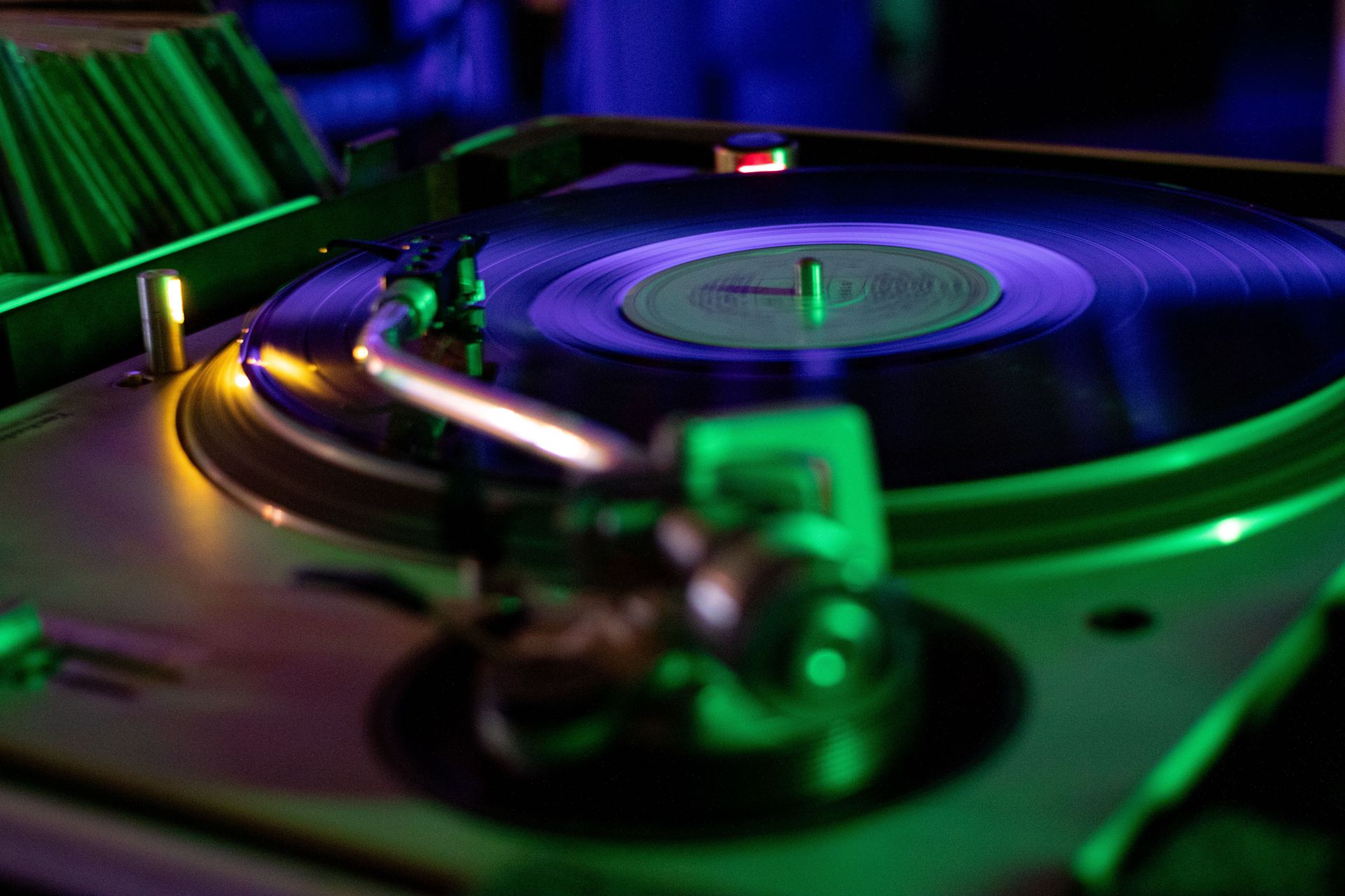 Vibrant vinyl record spinning on a turntable with vivid lighting effects.